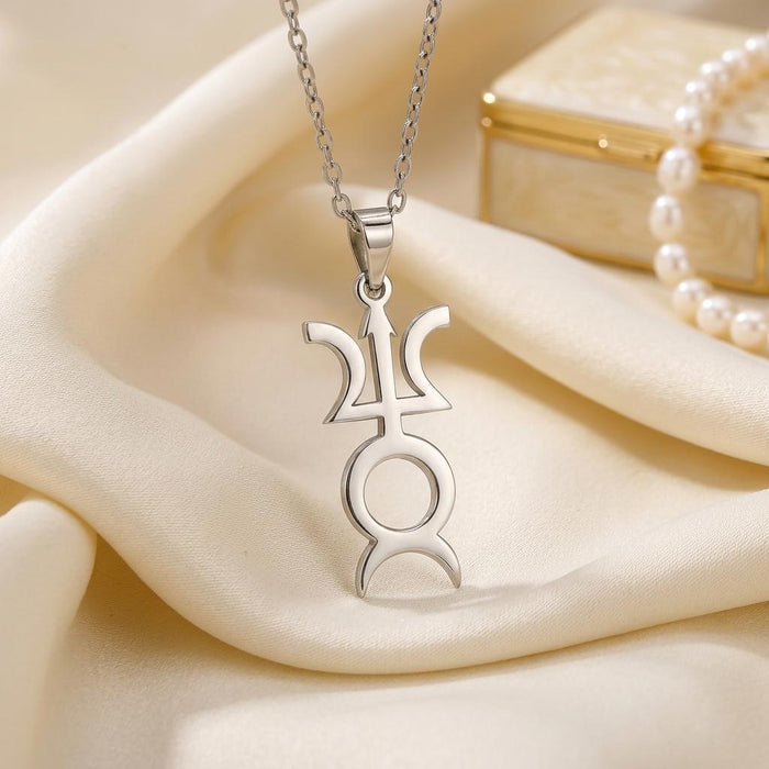 Silver Varuna symbol pendant on ivory satin beside pearls and a jewelry box
