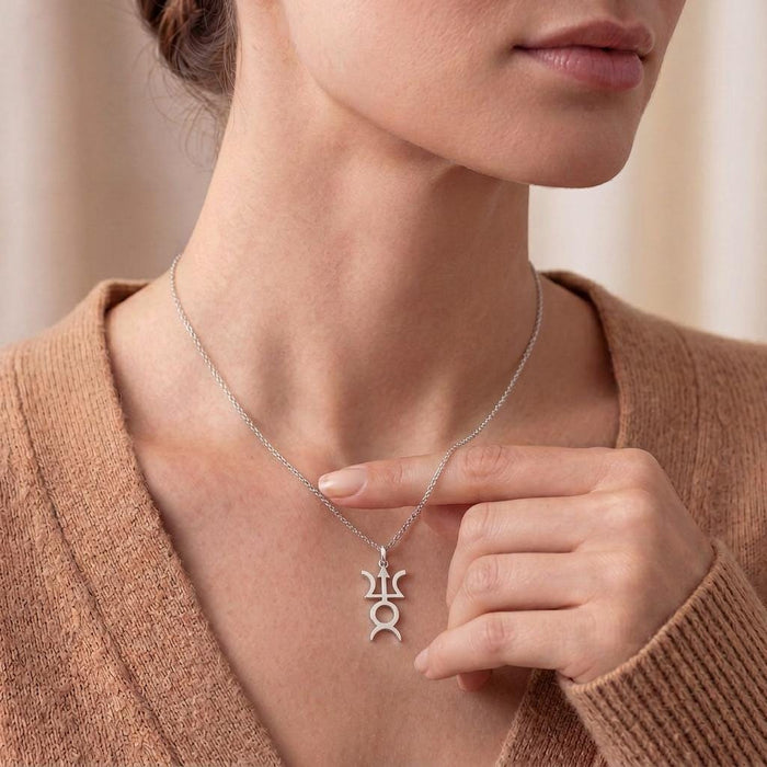Model holding a silver Varuna Symbol Necklace at the neckline