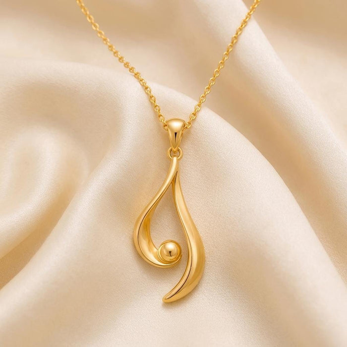 Gold Plated Silver Asymmetrical Aura Pendant close-up on ivory satin showing the extended outer curve