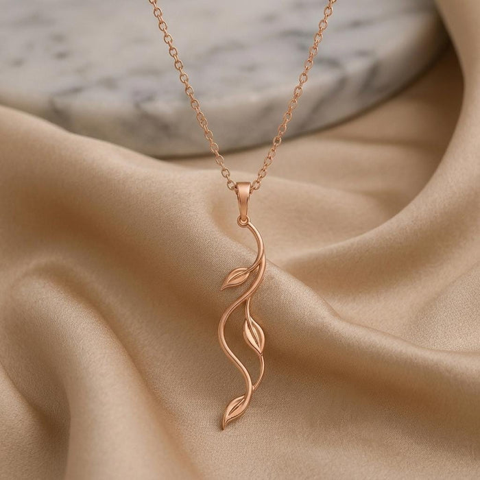 Rose Gold Plated Aurora Vine Necklace with two leaf-shaped openwork details displayed on champagne satin