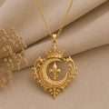 Gold Plated Silver Regal Moon Crest pendant with a crowned crescent and fleur-de-lis on textured beige fabric