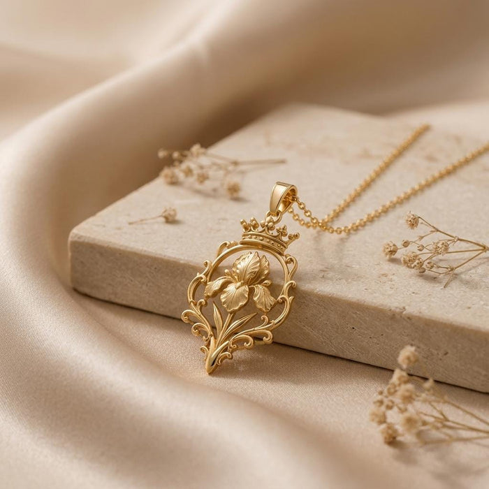 Gold Plated Silver iris-and-crown pendant necklace arranged on a stone slab with dried flowers