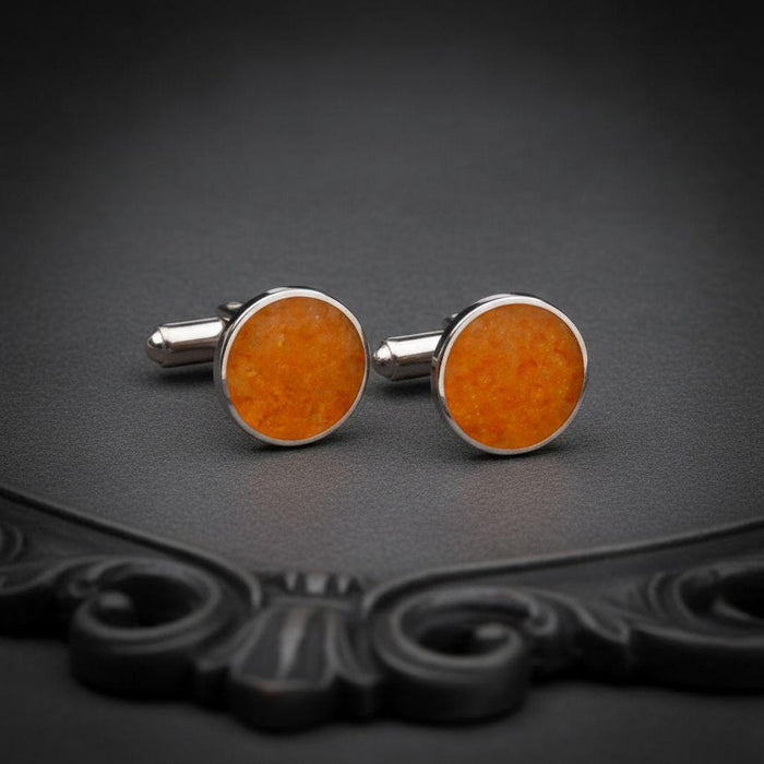 Front-facing pair of round amber stone cufflinks with orange-toned stone faces and cylindrical backs