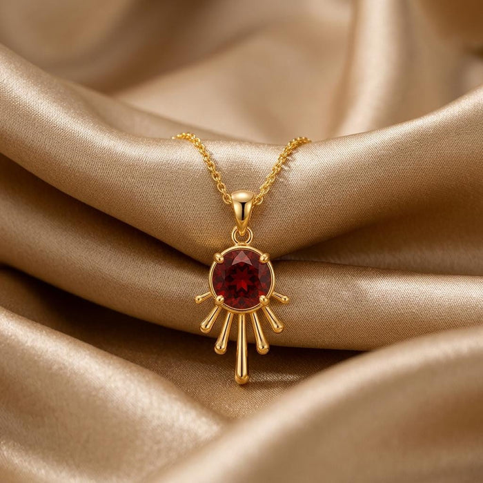 Gold Plated Silver Sun Drop Pendant Necklace with a deep red round center on champagne satin