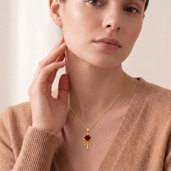 Model wearing a Gold Plated Silver Sun Drop Pendant Necklace with a deep red center and beige knit top