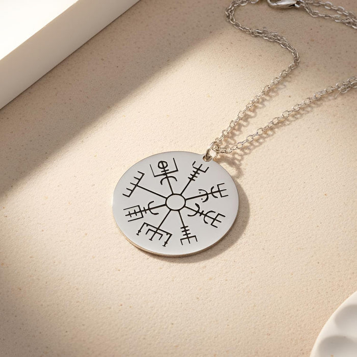 Silver Vegvisir Compass Necklace with a closed round engraved eight-arm compass pendant displayed on a textured light surface